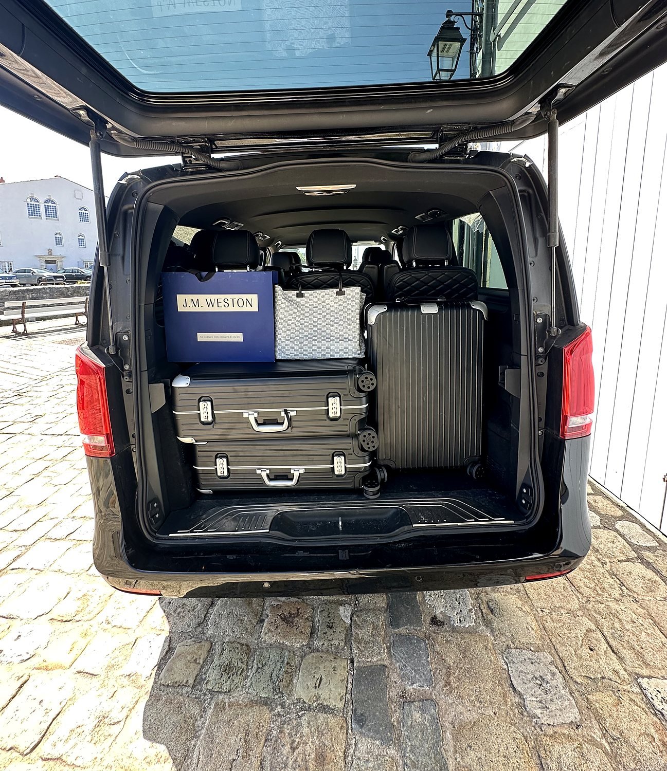 Coffre ouvert d'un Mercedes Classe V MyCourse chargé de valises