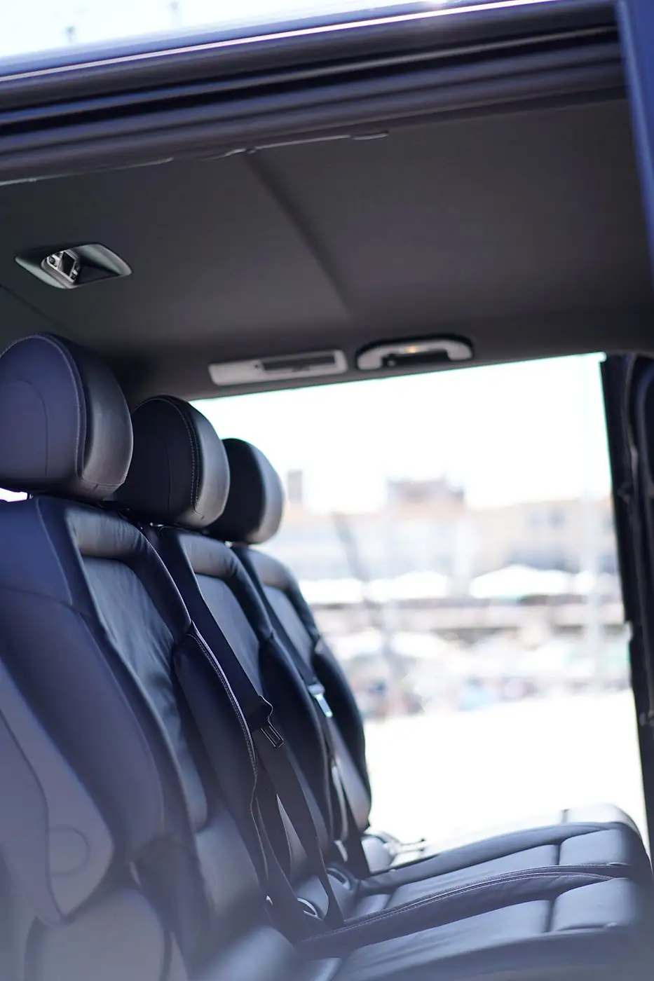 Leather seats of a MyCourse van, door open onto the Old Harbour of La Rochelle
