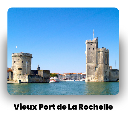 Two historic towers by the harbor in La Rochelle, France, with boats docked in calm water.